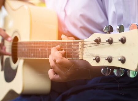 Hand of girl student playing guitar.