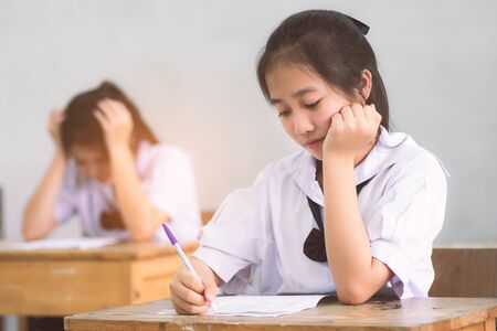 Smile young girl student reading and writing exam with not stress.の写真素材