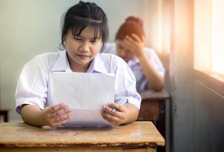 Portrait of young girl students writing the exam with smile.