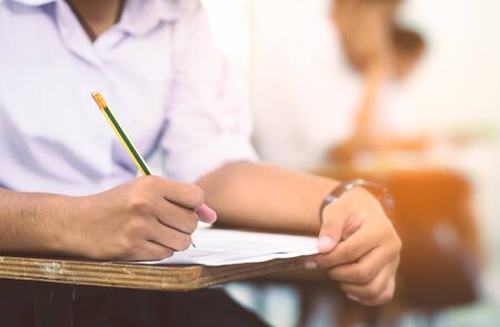 Student reading and writing exam with stress.