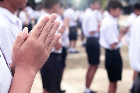 Hand of Asian students pay respect to the Buddha