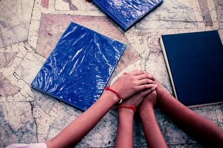 Top view of young uniform students putting their hands together. Friends with stack of hands showing unity and teamwork.の写真素材