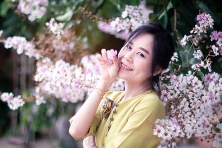 Smiling asian woman with spring flowersの写真素材