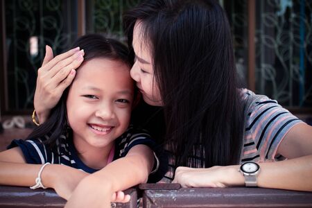 Portrait of mother kissing her daughter with loveの写真素材