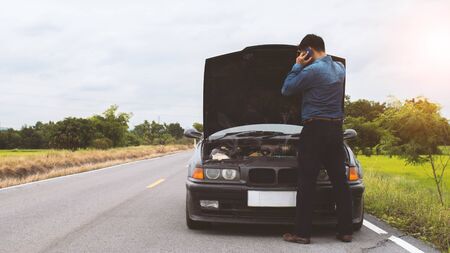 Man talking smartphone and looking engine system broken car on the road.16:9 style