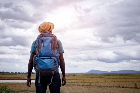 African tourist  traveler man with backpack on view of mountain backgroundの写真素材