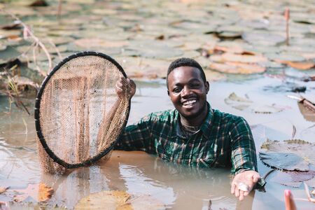 African fisherman smiling in flower lotus lakeの写真素材