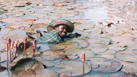 African fisherman smiling in flower lotus lakeの写真素材