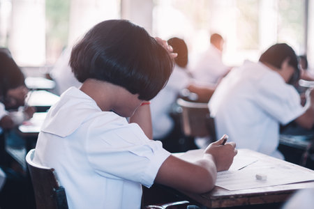 Students taking exam with stress in school classroomのeditorial素材