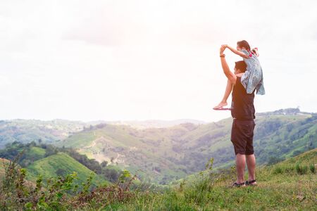 Asian little girl on his father shoulder standing on the top of mountain.の写真素材