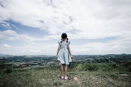 Alone asian child girl standing at the top of mountainの写真素材