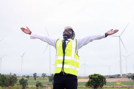 Freedom african engineer man standing with wind turbineの写真素材