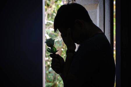 Sad man and rose in valentines day.Low key style.の写真素材
