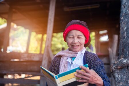 Asian seniors reading a book in countryside village of Thailandの写真素材