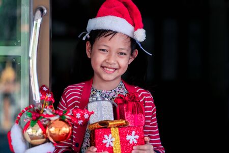 Asian smiling beautiful girl behind door at home.Christmas or X-mas conceptの写真素材