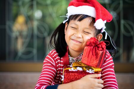 Smile asian cute girl received holiday gift with excited about unpacking her gift.の写真素材