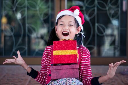 Smile asian cute girl received holiday gift with excited about unpacking her gift.の写真素材