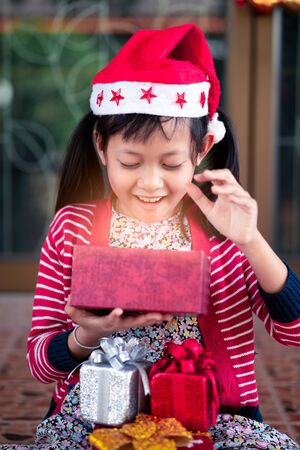 Cute girl received and open holiday gift with excited about her christmas box.の写真素材