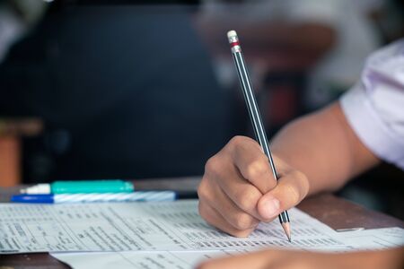 Hand of Student doing test or exam  in classroom of school with stressの写真素材