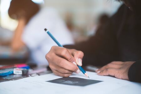 Hand of Student doing test or exam  in classroom of school with stressの写真素材