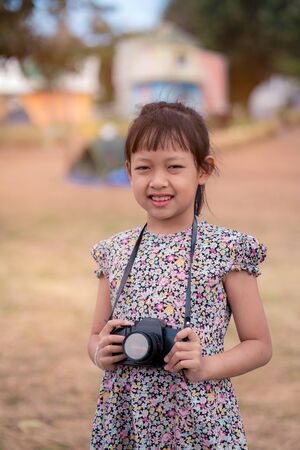 Asian little child girl holding film camera and taking photoの写真素材