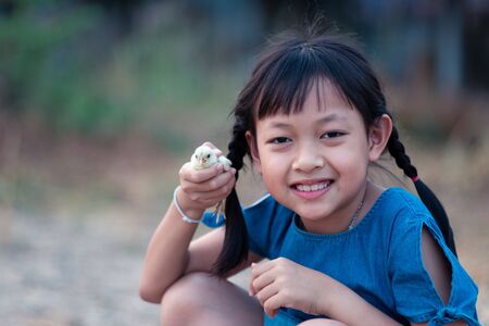 Asian little gilr  holding a chick in her hand with love and happy.の写真素材