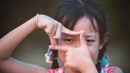Portrait of happy  asian child girl  with take sign fingers.16:9 styleの写真素材