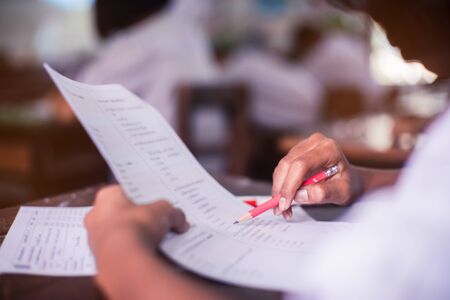 Students taking exam with stress in school classroom.の写真素材