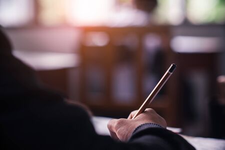 Students taking exam with stress in school classroom.の写真素材