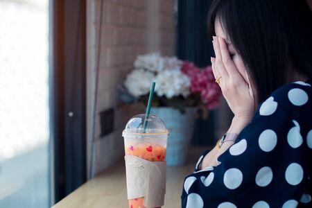Asian sad girl near window thinking about something with loneliness and unhappy in valentine day.の写真素材