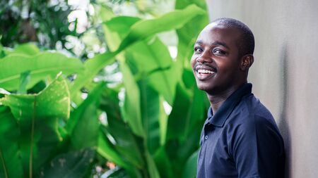 Portrait of african man smiling with green natural background.16:9 styleの写真素材