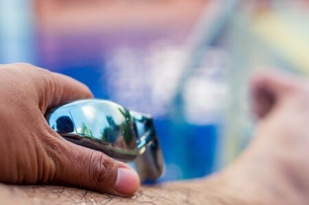 Swimming googles holding by swimmer naer the swimming pool