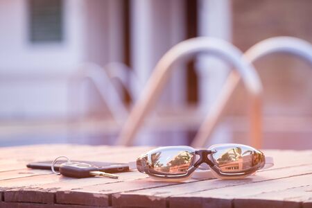 Swimming goggles on the wooden with the keys and smartphoneの写真素材