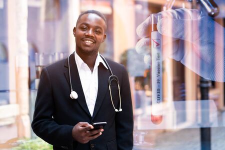 Double exposure african doctor,scientist expertise experiment smiling and holding a smartphone with miceoscope test virus and medicine pharmaceutical in glass tubeの写真素材