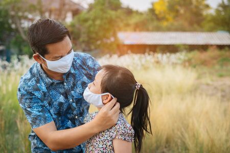 Father help his daughter wearing medical mask for protect 2019 - nCov , covid 19 or coronavirus.の写真素材