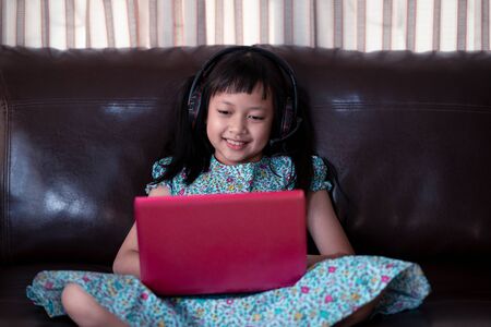 Cute asian little child girl studying  online lesson at home, social distance during quarantine,...