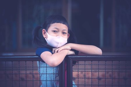 Portrait asian little child girl wearing  face mask stay at home during covid-19 lock down.の写真素材