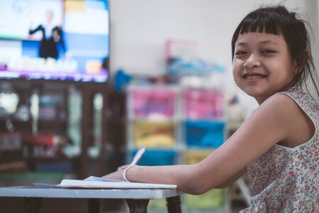 Little child girl learning on TV or Distance Learning Television at home,Social distance during quarantine, Online education conceptの写真素材
