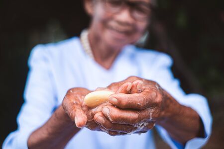Close up to old woman washing his hands with soapの写真素材