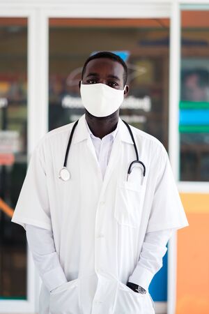 African doctor wear face mask and holding stethoscopeの写真素材