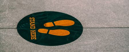 Stand here foot sign or symbol on the floorの写真素材