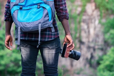 African man traveler holding camera with backpack