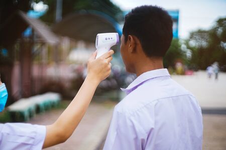 Temperature check uniform studen for protect covid-19 or virus  in school.Back to school concept.の写真素材