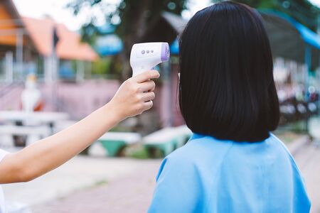 Temperature check uniform studen for protect covid-19 or virus  in school.Back to school concept.の写真素材