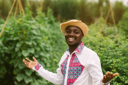 African farmer man standing in the organic farm with wearing native clothes . Agriculture or cultivation conceptの写真素材