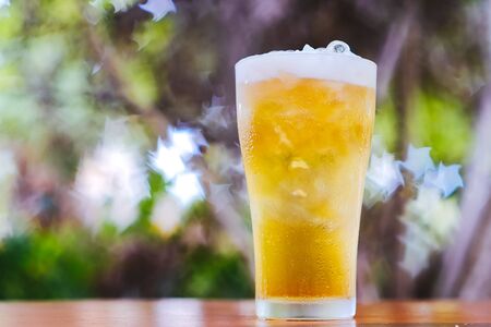 Cold Beer in a glasses with nature bokeh backgroundの写真素材