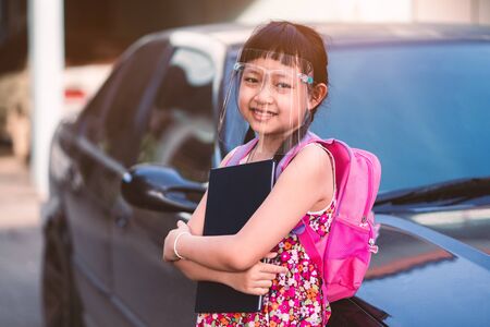 Asian little girl student wearing face shield during she going back to school after covid-19 quarantine.の写真素材