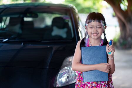 Asian little girl student wearing face shield during she going back to school after covid-19 quarantine.の写真素材