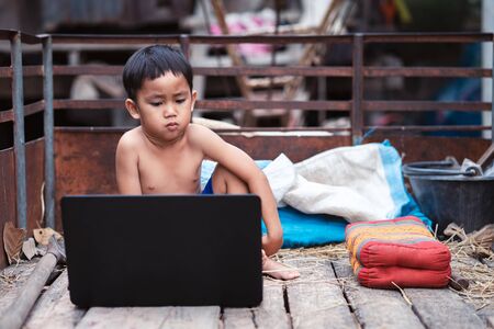 Little boy watching and  studying  online learning  with laptop in countrysideの写真素材