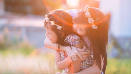 Happy smiling daughter and  her mother hugging with beautiful light flare.Mother day and family conceptの写真素材